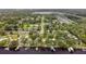A serene aerial view of a home situated by a tranquil body of water and surrounded by a lush green landscape at 9501 Alice Ln, Riverview, FL 33578