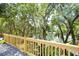 Wooden deck overlooking backyard scenery filled with lush green trees and a pond at 9501 Alice Ln, Riverview, FL 33578