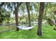 Lush backyard featuring a relaxing hammock strung between mature trees, offering a serene escape with a tranquil water view at 9501 Alice Ln, Riverview, FL 33578