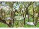 Private waterfront backyard with mature trees, lush lawn, and a serene hammock for ultimate relaxation at 9501 Alice Ln, Riverview, FL 33578