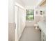 A bathroom with retro style white tile, a tub/shower with a patterned curtain and a long vanity with one sink at 9501 Alice Ln, Riverview, FL 33578