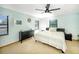 A well-lit bedroom features soft aqua walls, carpet floors, ceiling fan, and a beachy decor at 9501 Alice Ln, Riverview, FL 33578
