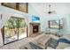 Living room with stone fireplace, a large window, and sliding doors to the deck overlooking a peaceful lake at 9501 Alice Ln, Riverview, FL 33578