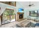 Cozy living room with stone fireplace, large windows, and access to the outdoor deck with water views at 9501 Alice Ln, Riverview, FL 33578