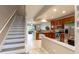 Open-concept kitchen with stainless steel appliances, wood cabinets, and a staircase leading to the living area at 10214 Post Harvest Dr, Riverview, FL 33578