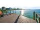 Waterfront view from a wooden dock with bench seating, overlooking the ocean and nearby buildings on a sunny day at 1100 Pinellas Bayway S # H2, Tierra Verde, FL 33715