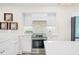 Bright kitchen featuring stainless steel appliances, white cabinets, and unique backsplash at 1100 Pinellas Bayway S # H2, Tierra Verde, FL 33715