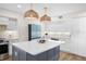 Open kitchen with a center island, stainless steel appliances, and unique backsplash at 1100 Pinellas Bayway S # H2, Tierra Verde, FL 33715