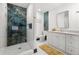 Bathroom featuring double vanity, marble countertops, and elegant shower with designer tile at 1103 E Louisiana Ave, Tampa, FL 33603