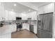 Modern kitchen with white cabinetry, marble backsplash, stainless steel appliances, and hardwood floors at 1103 E Louisiana Ave, Tampa, FL 33603