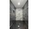 Modern shower featuring black hexagon tile floors and marble accent tile at 1103 E Louisiana Ave, Tampa, FL 33603