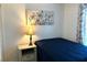Bedroom featuring a bed, nightstand, lamp, and floral art at 1109 Pine Ridge W Cir # F1, Tarpon Springs, FL 34688