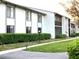 Condo exterior featuring well-maintained landscaping, including green bushes and a sidewalk at 1109 Pine Ridge W Cir # F1, Tarpon Springs, FL 34688