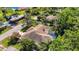 Overhead shot of a brown roof home with a screened pool amid lush greenery and mature trees at 12010 Hardaman Pl, Tampa, FL 33618