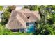 Aerial view of a brown roof home with a screened pool and well-manicured landscaping at 12010 Hardaman Pl, Tampa, FL 33618