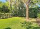 Secluded backyard features a lush green lawn, privacy fence, and mature trees, offering a serene outdoor retreat at 12010 Hardaman Pl, Tampa, FL 33618
