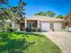 Charming single-story home with a manicured lawn and a three-car garage offers inviting curb appeal at 12010 Hardaman Pl, Tampa, FL 33618