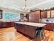 Spacious kitchen features custom wood cabinetry, a central island with seating, and high-end appliances at 12010 Hardaman Pl, Tampa, FL 33618