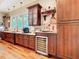 Custom kitchen with wine fridge, wood cabinetry, and granite countertops at 12010 Hardaman Pl, Tampa, FL 33618