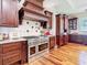Chef's kitchen featuring a professional-grade range, custom hood, and elegant cabinetry at 12010 Hardaman Pl, Tampa, FL 33618