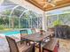Inviting screened patio features a dining set, ceiling fan, and a view of the sparkling pool and landscaped backyard at 12010 Hardaman Pl, Tampa, FL 33618