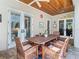 Covered patio features brick flooring, wood ceilings, ceiling fan, and direct access to interior through french doors at 12010 Hardaman Pl, Tampa, FL 33618