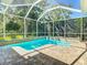 Inviting in-ground swimming pool with a screened-in lanai and brick trim, perfect for relaxing and entertaining at 12010 Hardaman Pl, Tampa, FL 33618
