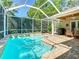Screened pool deck with in-ground pool, patio area and outdoor kitchen, offers a private outdoor oasis at 12010 Hardaman Pl, Tampa, FL 33618