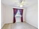 Bedroom with wood floors, a ceiling fan, and a window with dark red curtains at 12520 Saint Charlotte Dr, Tampa, FL 33618