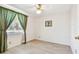 Bright bedroom features wood-look floors, ceiling fan, and large window with decorative green curtains at 12520 Saint Charlotte Dr, Tampa, FL 33618