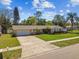 Well-maintained single-Gathering home with a long driveway, lush lawn, and mature landscaping, under a blue sky at 12520 Saint Charlotte Dr, Tampa, FL 33618