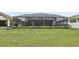 Backyard includes a screened-in patio, an expansive lawn, and manicured shrubbery at 13176 Twin Bridges Dr, Riverview, FL 33579