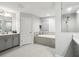 Bright bathroom features a soaking tub, a glass-enclosed shower, and a double vanity, designed for relaxation at 13176 Twin Bridges Dr, Riverview, FL 33579
