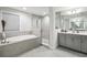 Serene bathroom with a soaking tub, a glass-enclosed shower, and a double vanity, designed for relaxation at 13176 Twin Bridges Dr, Riverview, FL 33579
