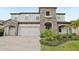 Charming two-story home featuring a stone facade, arched entryways, and manicured landscaping at 13176 Twin Bridges Dr, Riverview, FL 33579