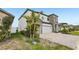 Side angle of a two-story home with stone, neutral siding, landscaping, and paved driveway at 13176 Twin Bridges Dr, Riverview, FL 33579