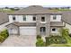 Stunning two-story home with beautiful stone accents, a three-car garage, and landscaped front yard at 13176 Twin Bridges Dr, Riverview, FL 33579