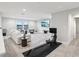 Living room featuring bright white walls, large windows, plush seating, and a modern rowing machine at 13176 Twin Bridges Dr, Riverview, FL 33579