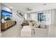 Bright living room showcasing a large sectional sofa, staircase, and sliding glass doors to the pool at 13176 Twin Bridges Dr, Riverview, FL 33579