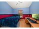 Bedroom featuring blue and red color scheme with a bed and a computer desk with an exterior view at 1416 Watermill Cir, Tarpon Springs, FL 34689