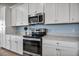 Modern kitchen features stainless steel appliances, white cabinets, and light countertops at 17724 Gawthrop Dr # 402, Bradenton, FL 34211