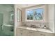 Bright bathroom with double vanity, marble backsplash, and glass-enclosed shower at 1774 Cherokee Dr, Sarasota, FL 34239