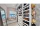 Custom walk-in closet with built-in shelving, seating, and a large mirror, offering ample storage and organization at 1774 Cherokee Dr, Sarasota, FL 34239