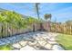 Charming backyard stone patio features a wood pergola, surrounding fence and tropical foliage at 1842 Oklahoma Ne Ave, St Petersburg, FL 33703