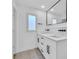 Bright bathroom with white cabinets, dual sinks, quartz countertop, black hardware and a geometric-tiled floor at 1842 Oklahoma Ne Ave, St Petersburg, FL 33703