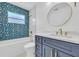 Charming bathroom featuring geometric-tile accent wall, modern vanity with gold hardware, and round mirror at 1842 Oklahoma Ne Ave, St Petersburg, FL 33703
