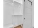 White minimalist walk-in closet with wood floor and custom storage solutions at 1842 Oklahoma Ne Ave, St Petersburg, FL 33703