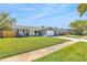 Charming gray brick home with lush green lawn, two-car garage and well-maintained landscaping at 1842 Oklahoma Ne Ave, St Petersburg, FL 33703