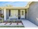 Charming front porch with white bench seating, decorative pillows, and well-maintained landscaping at 1842 Oklahoma Ne Ave, St Petersburg, FL 33703