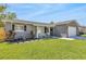 Well-manicured front yard featuring a gray brick home with lush green lawn and sidewalk leading to the front door at 1842 Oklahoma Ne Ave, St Petersburg, FL 33703